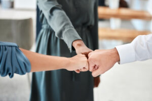 Three people holding their fists together