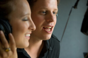 A man and a woman in the studion singing