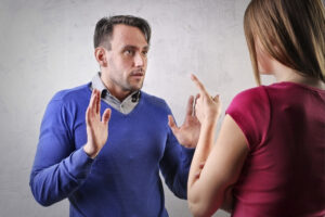 A man and a woman talking and pointing their fingers