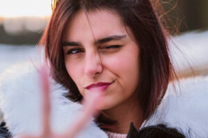A person closing one eye to the camera