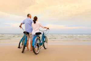 Two persons with bicycles on the beach