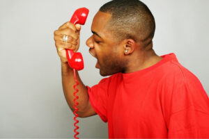a person in a red shirt talking on a red telephone