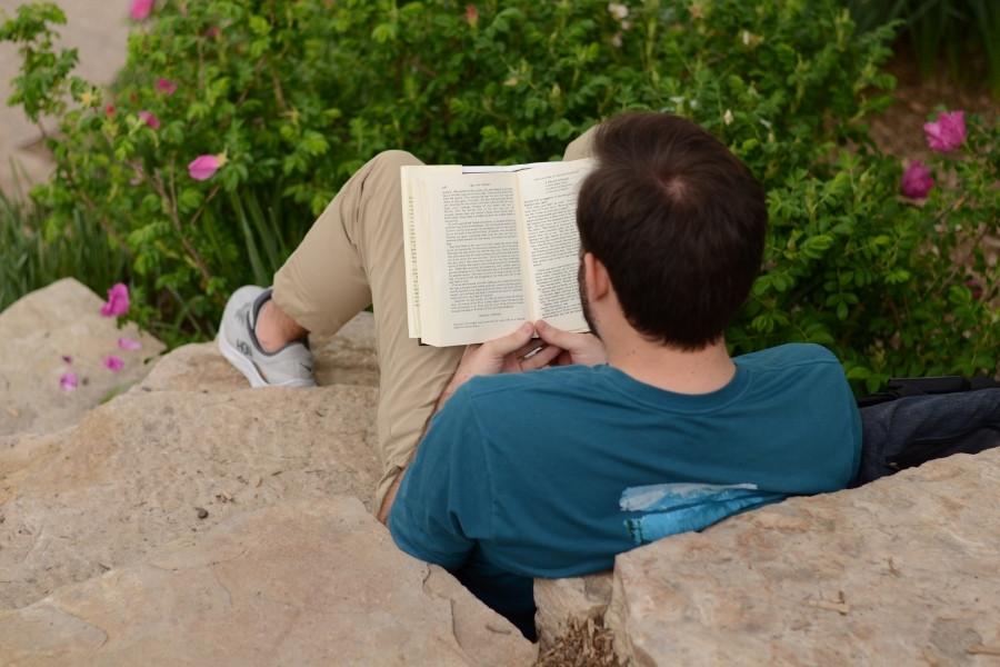 A person reading a book on the stairs