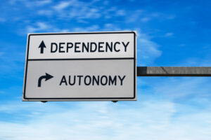 a street sign with the words dependency and autonomy