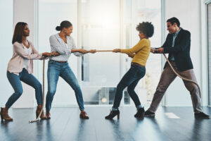 a group of people playing tug of war in an office