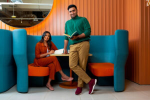 Two people sitting on a couch in an office