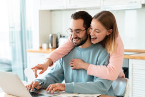 Two people sitting at a table with a laptop
