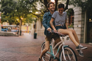 Two people riding on a bicycle in the city