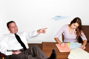 a person sitting at a desk with another person sitting next to them