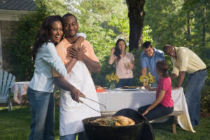 A couple smoking a steak in the company of other couples.