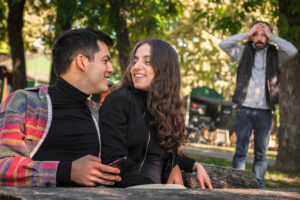 Two people are sitting on a bench in a park