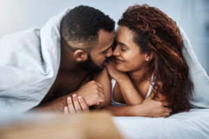 A couple cuddling in bed
