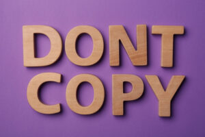 the word don't copy written in wooden letters on a purple background