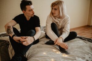 Two people sitting on a bed with candles