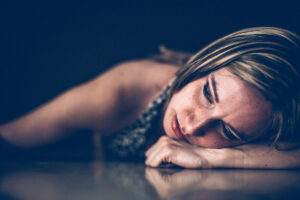 a person laying on the floor with their head in their hands