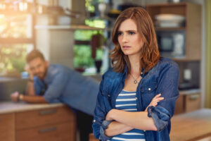 a person standing in a kitchen with their arms crossed