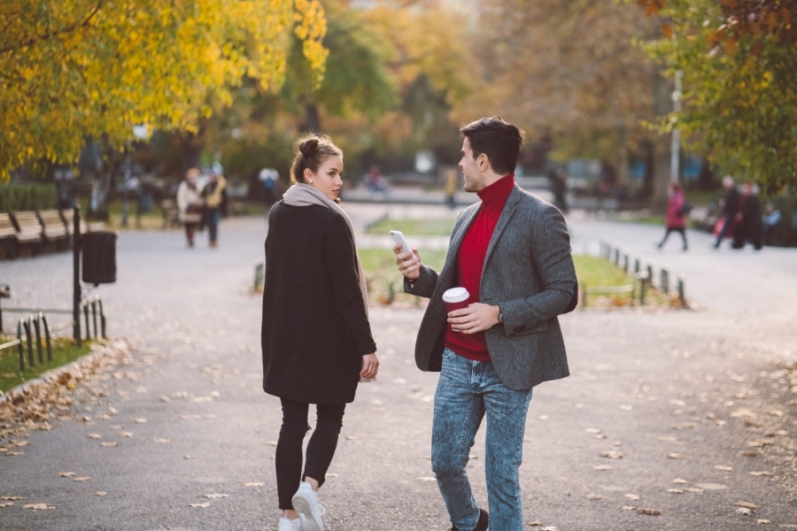 A man looking behind at a woman walking by