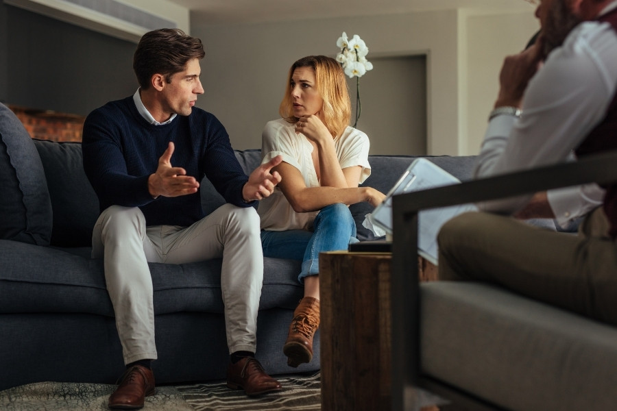 Three person sitting and talking in a living room