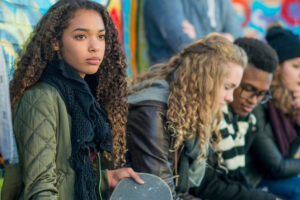 a group of people sitting in front of a graffiti wall