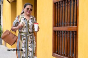 a woman walking down the street holding a coffee