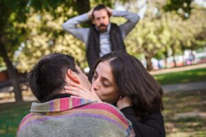 a person is kissing another person in the park