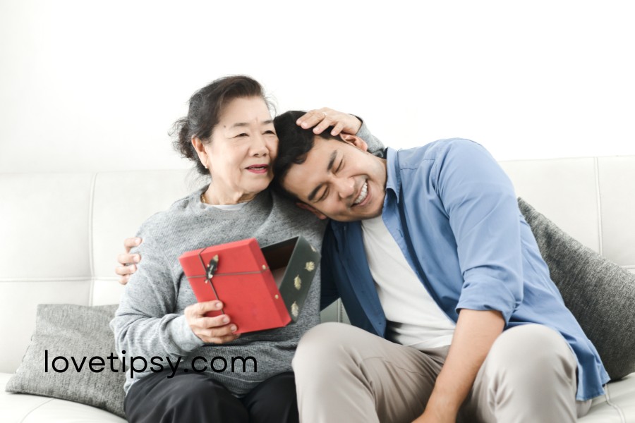 A man and woman sitting on a couch with a gift