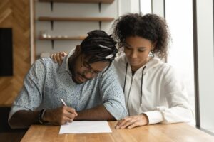 A couple signing a contract in their home