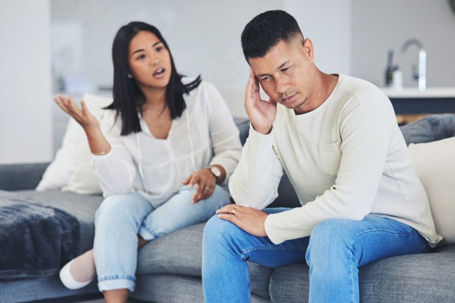 Two people are sitting on a couch in a living room