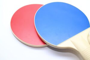 two ping pong paddles on a white surface
