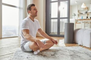 a person meditating in their living room