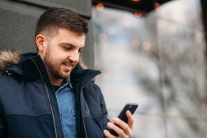 a person in a blue jacket is looking at their phone