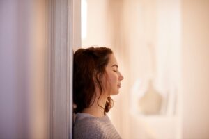 a person standing in front of a door with their eyes closed