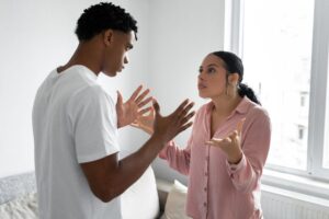 Two people arguing in a bedroom.