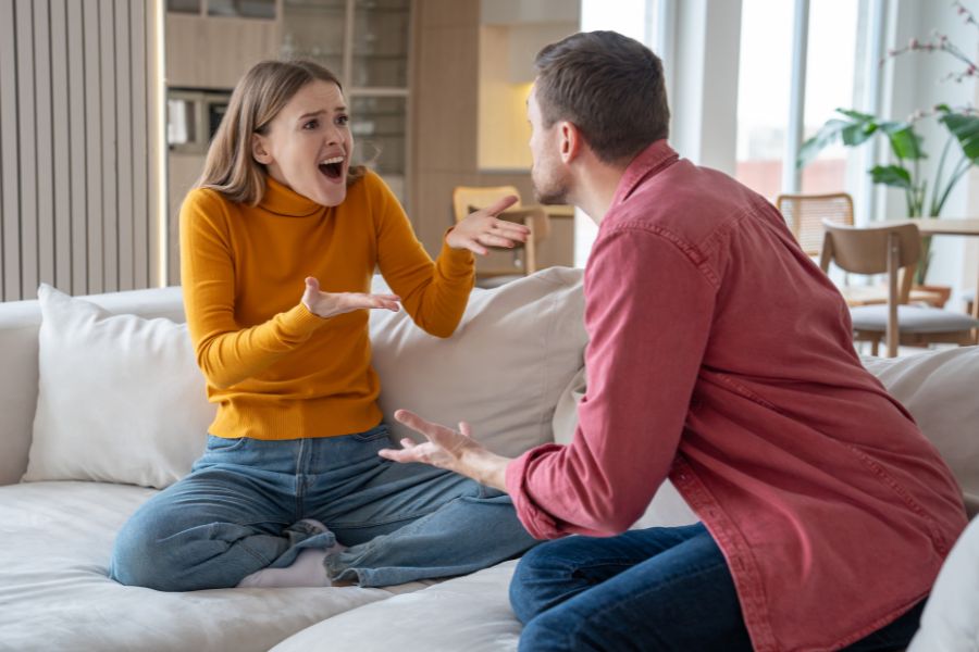 Two people are having an argument on a couch.