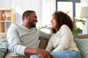 couple sitting on couch smiling at each other