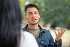 A man talking to a woman whose back is to the camera