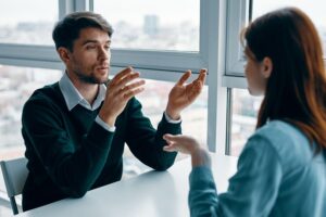 Two people sitting at a table talking to each other