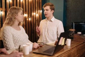 Two people at a coffee shop talking to each other