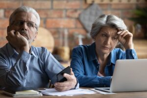 A couple sitting at a table with a laptop