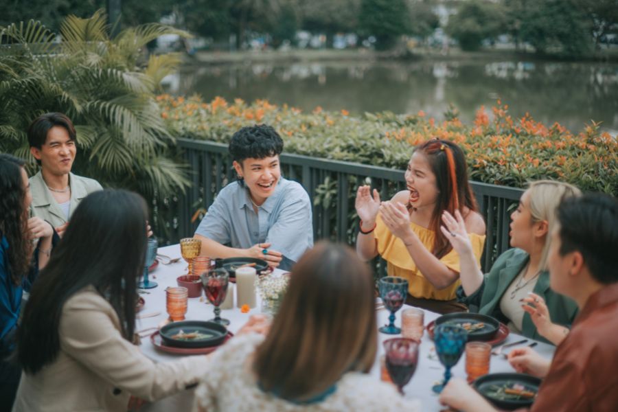 a group of people sitting around a table with food