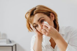 a person is wiping their eye with a tissue