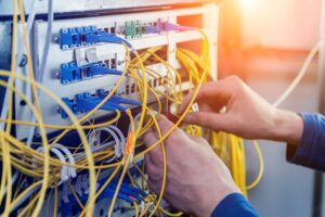a person is working on a network cable in a server room
